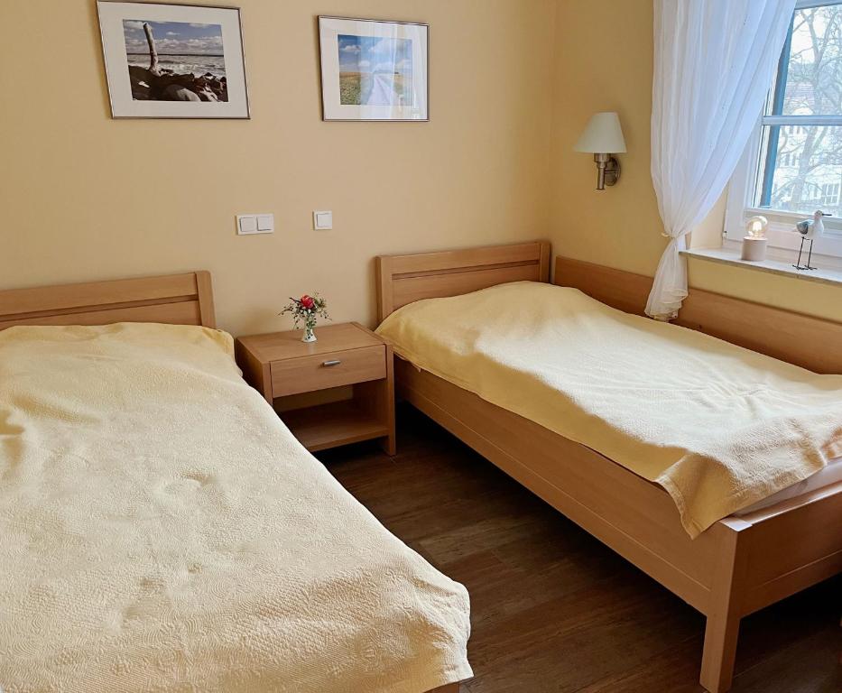 two beds in a small bedroom with a window at Ferienwohnung Strandflair in Baabe