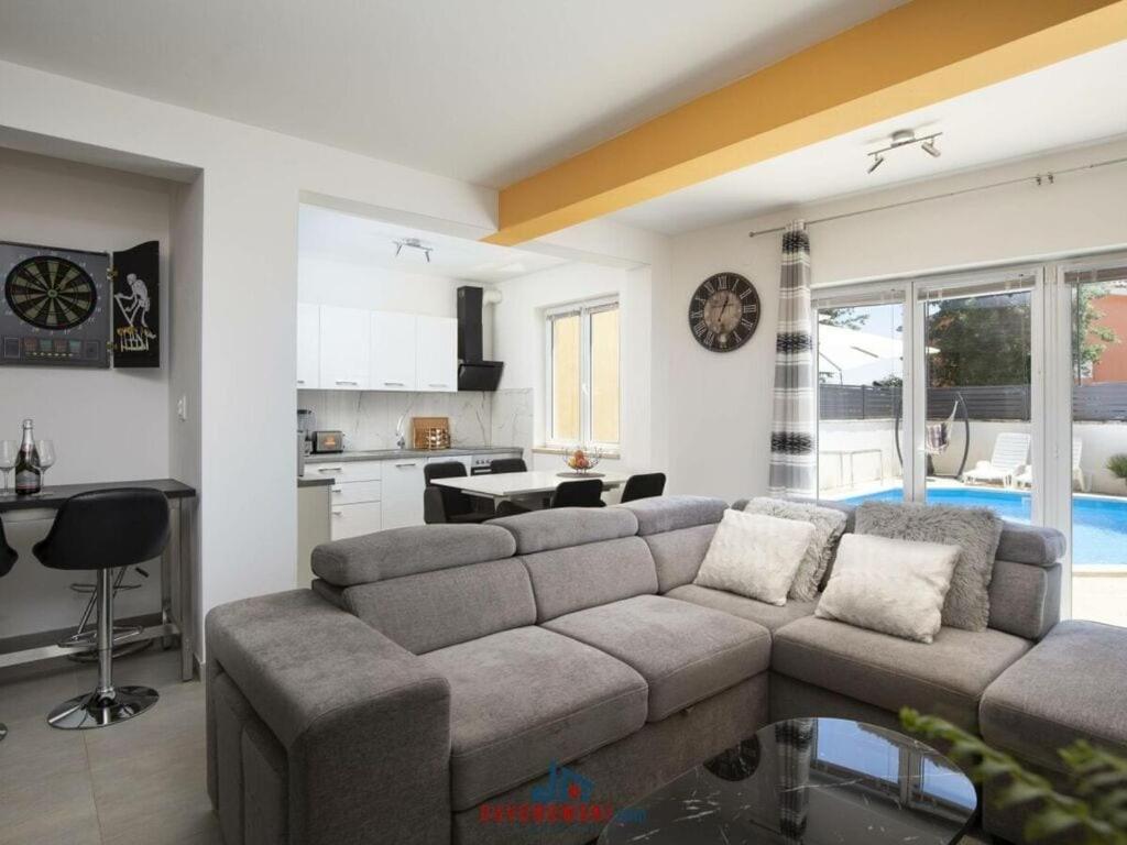 uma sala de estar com um sofá e uma cozinha em Villa Kostre Comfortable holiday residence em Loborika