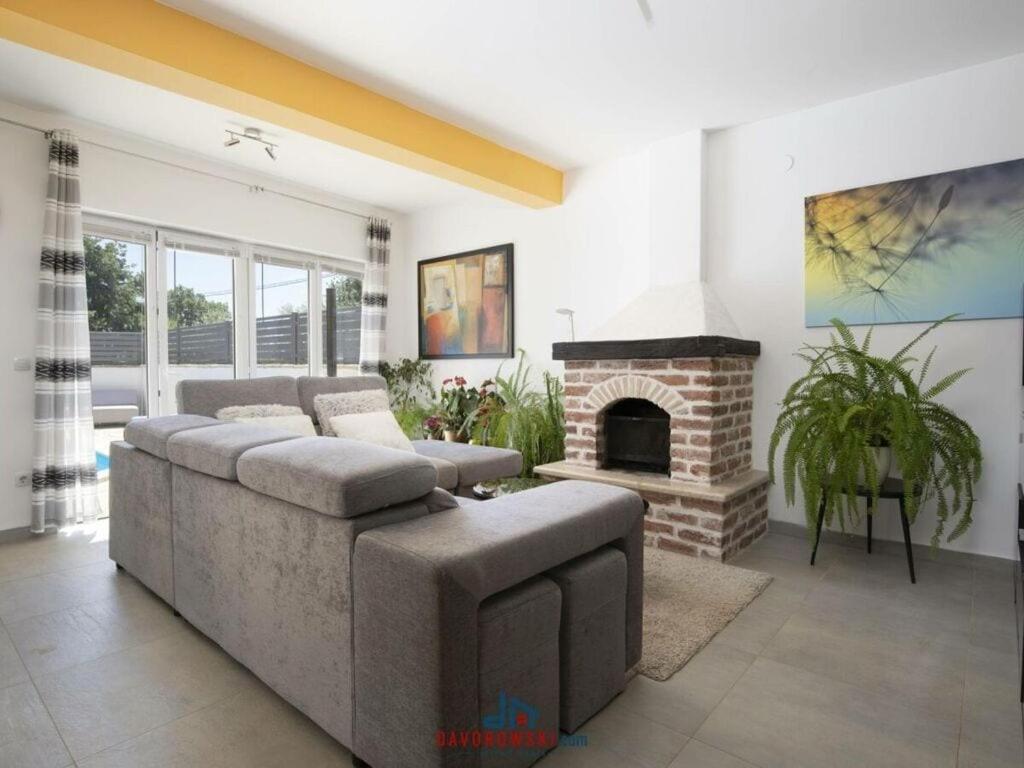 uma sala de estar com um sofá e uma lareira em Villa Kostre Comfortable holiday residence em Loborika