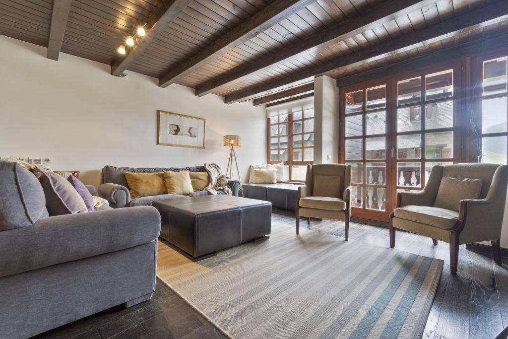 sala de estar con sofá, mesa y sillas en Luderna - Casa con terraza Unhola, en Bagergue