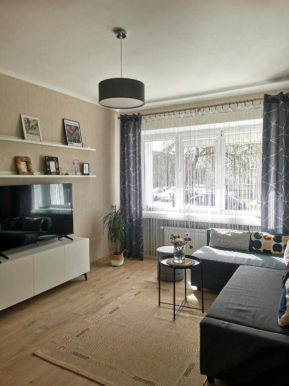 a living room with a couch and a tv at The good stay in Šiauliai