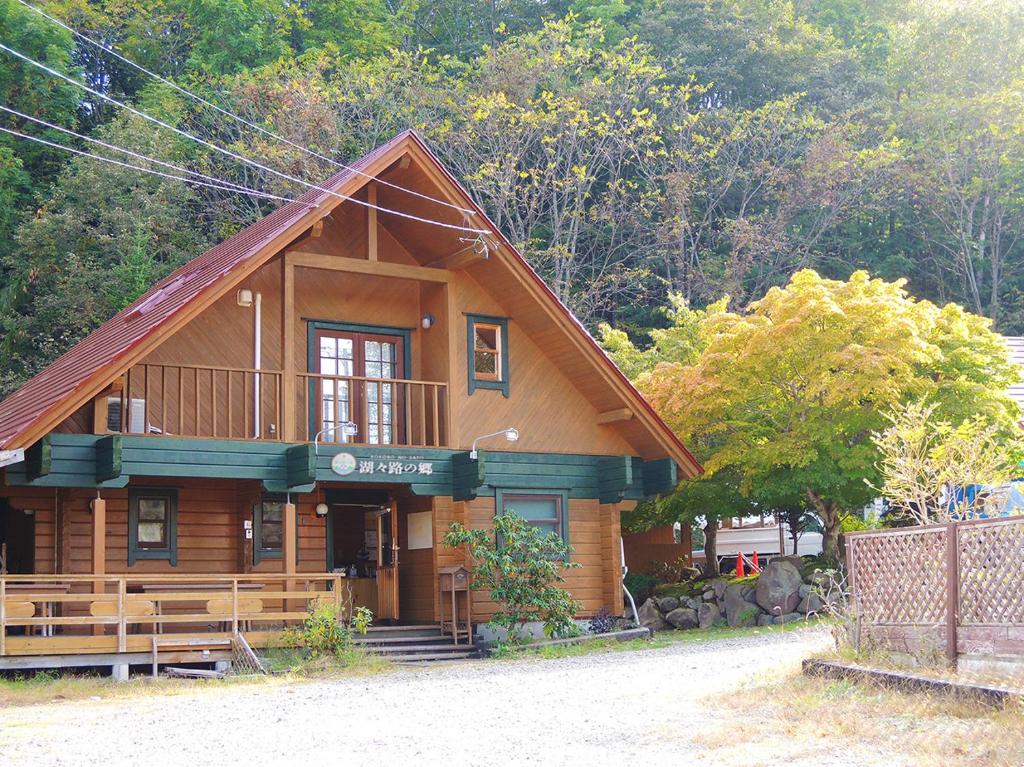 una baita di tronchi con veranda e balcone. di Kokoro no sato a Kamishihoro