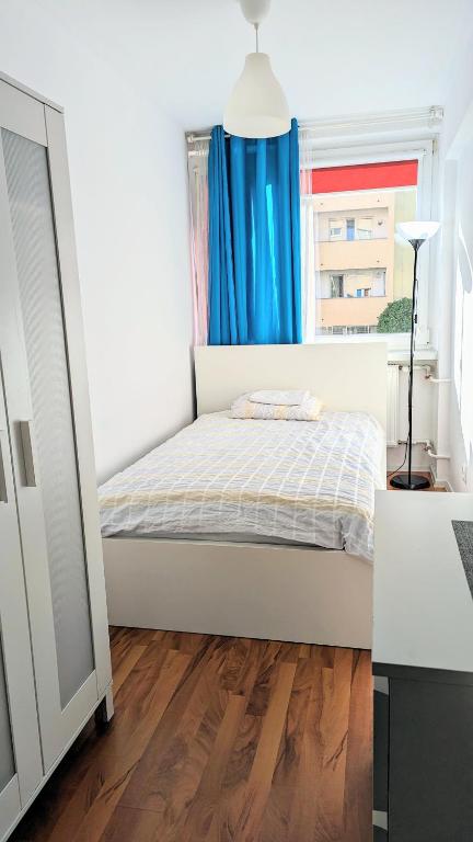 um pequeno quarto com uma cama e uma janela em Ursus Rooms-Self Check-in em Varósvia