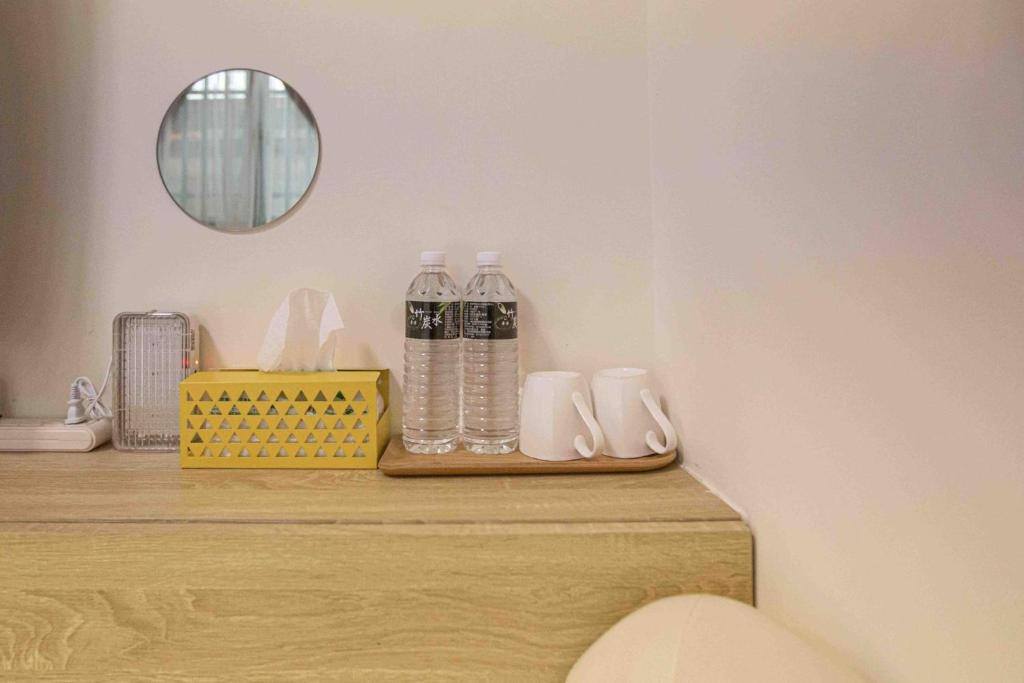 a counter with bottles of water and a mirror at 里舍民宿 in Jincheng