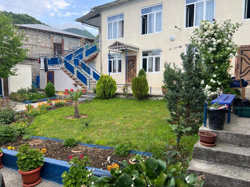 a house with a yard with flowers and plants at Garden house in Ambrolauri