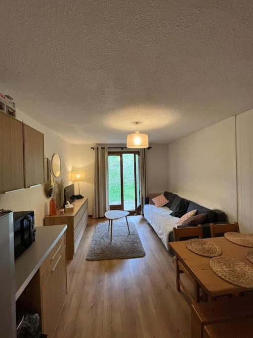 un salon avec un canapé et une table dans l'établissement Studio au pied des pistes, à Demi-Quartier