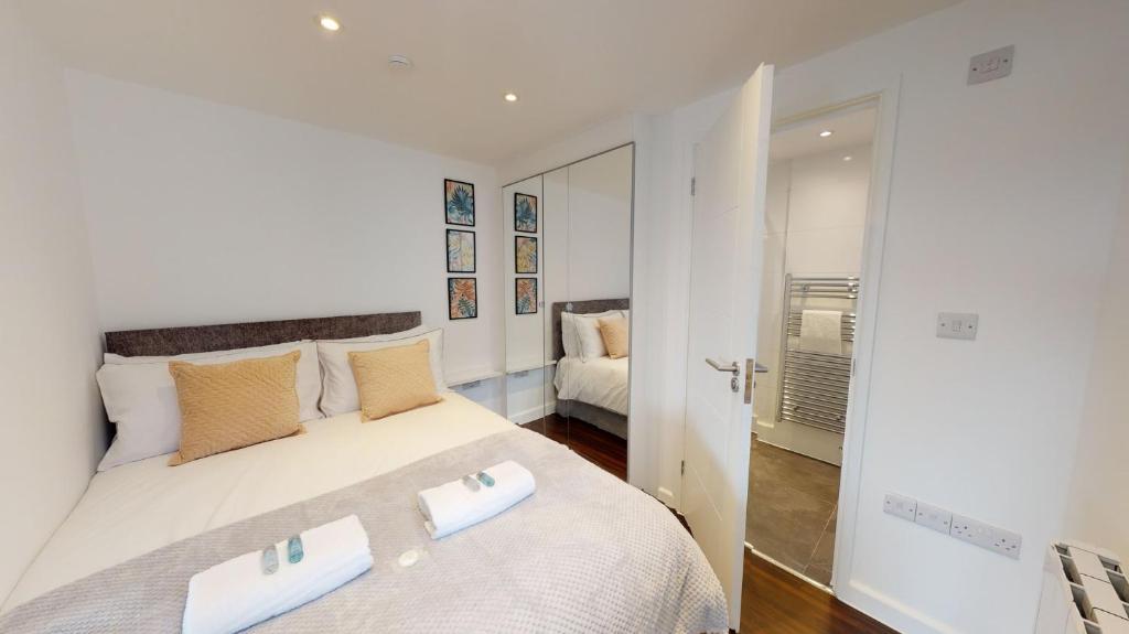 um quarto com uma grande cama branca e 2 almofadas em Stylish Apartment w/ Private Garden - Dog Friendly em Newport