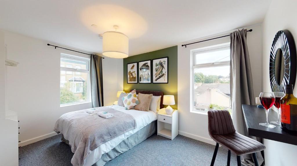 a bedroom with a bed and two windows at Stylish Duplex Apartment with Home Office in Newport