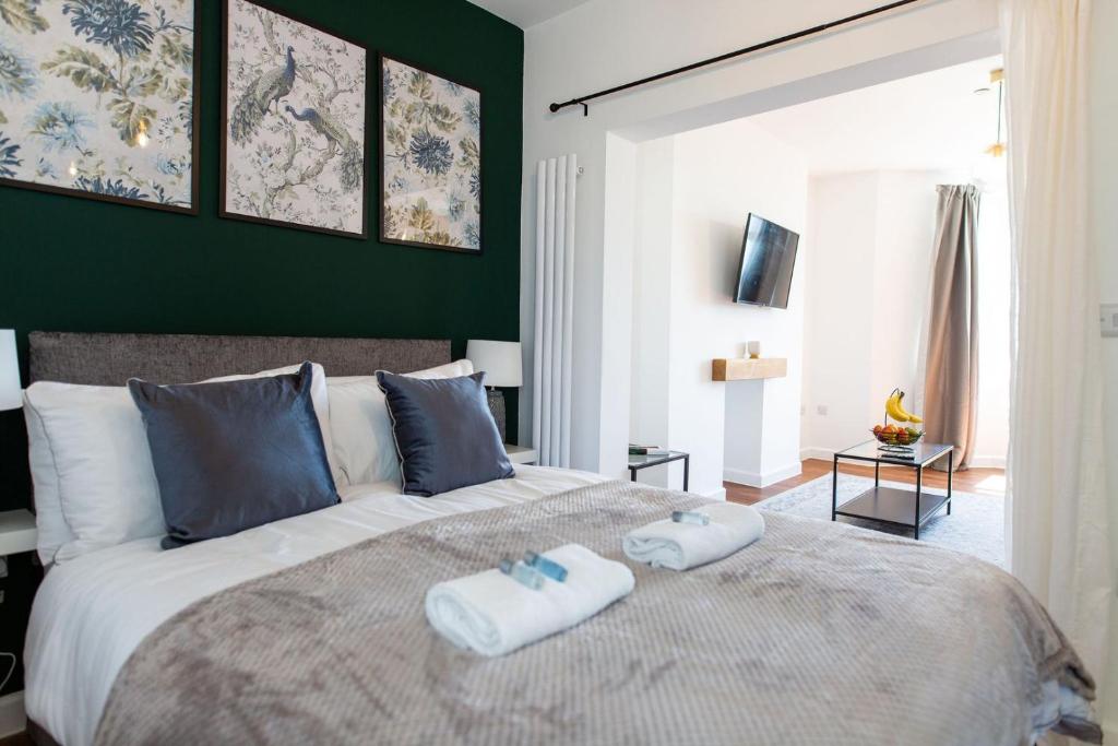 a bedroom with a large bed with two towels on it at Studio Apartment with 65" Smart TV in Newport