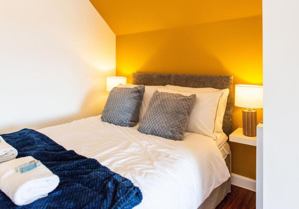 a bedroom with a large bed with yellow walls at Stylish Loft Apartment with View in Newport