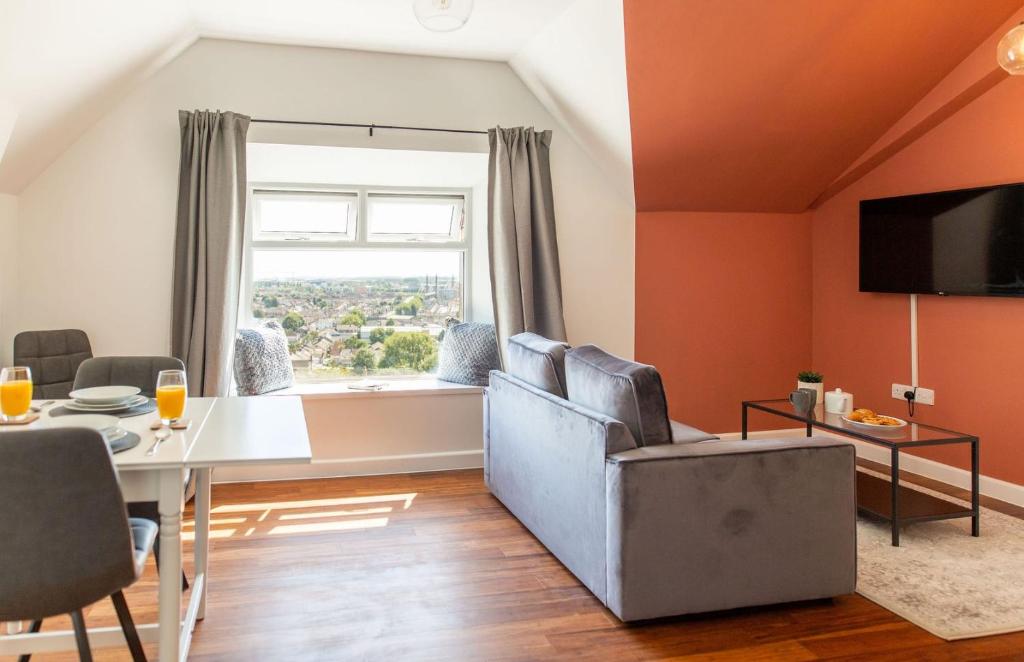 a living room with orange walls and a table and chairs at Stylish Loft Apartment with View in Newport