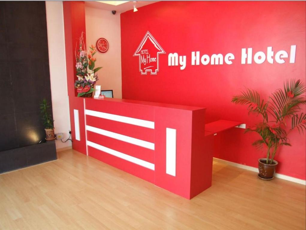 a room with a red wall with a home hotel sign at V Hotel Sri Gombak (Previously MyHome Hotel) in Batu Caves