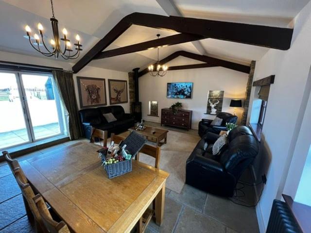 a living room with a couch and a table at Beautiful newly converted barn in St Hilary in Cowbridge