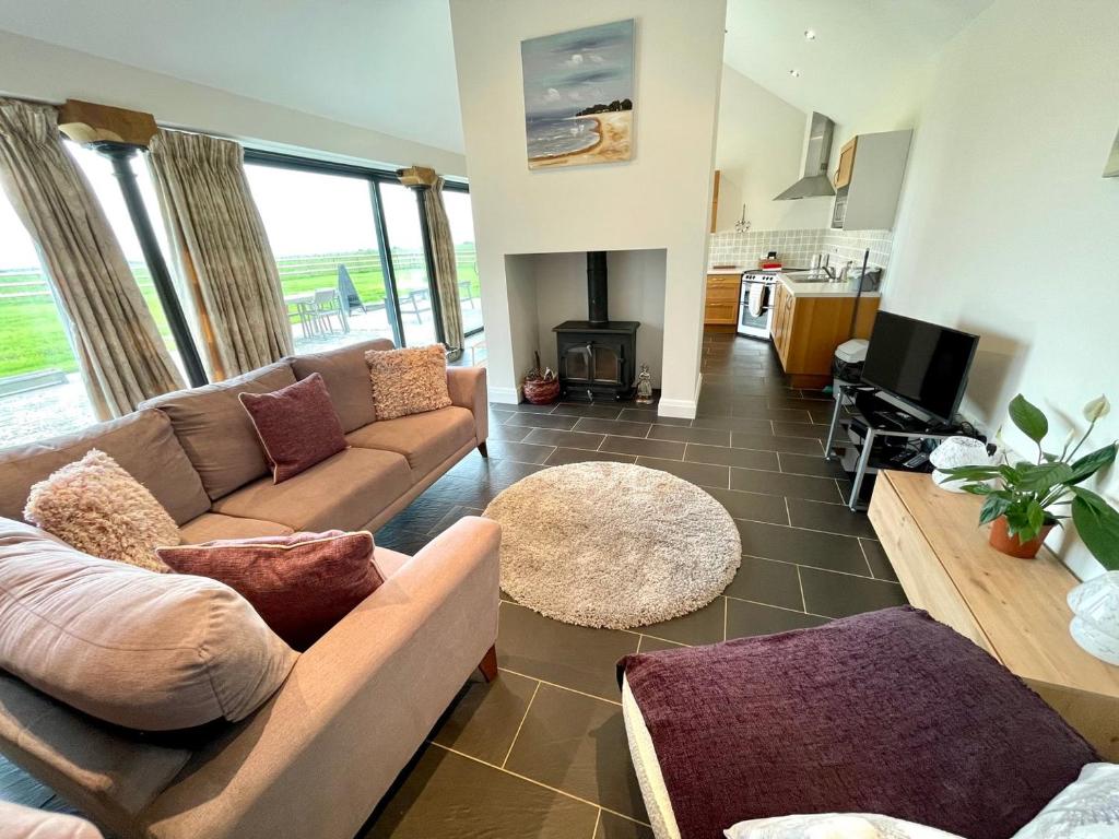 sala de estar con sofá y TV en Cosy barn with views in Wick Vale of Glamorgan, en Wick