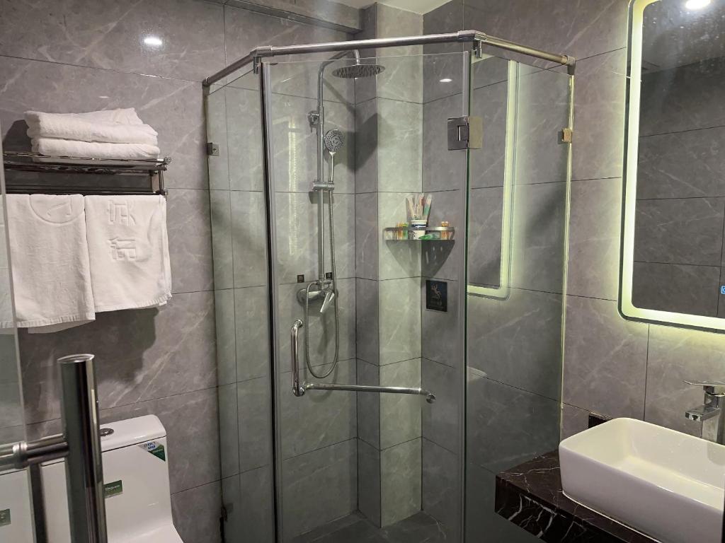y baño con ducha y lavamanos. en Biling Hotel en Fangshan