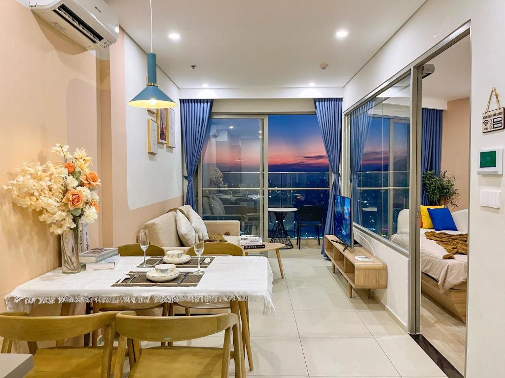 a living room with a table and a living room with a view at The Song Luxury Condotel Vung Tau - Xuân's Homestay in Vung Tau
