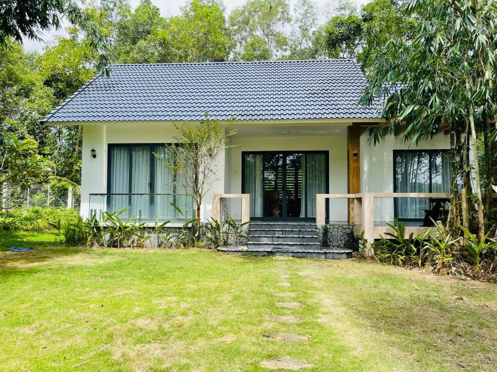 a small house with a grass yard in front of it at Sao Beach Bungalow in Phu Quoc