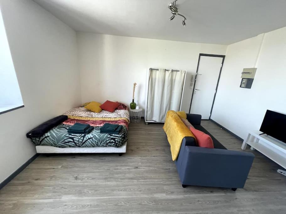 une chambre avec un lit et un canapé dans l'établissement Studio Cosy 3 proche gare, à Saint-Quentin