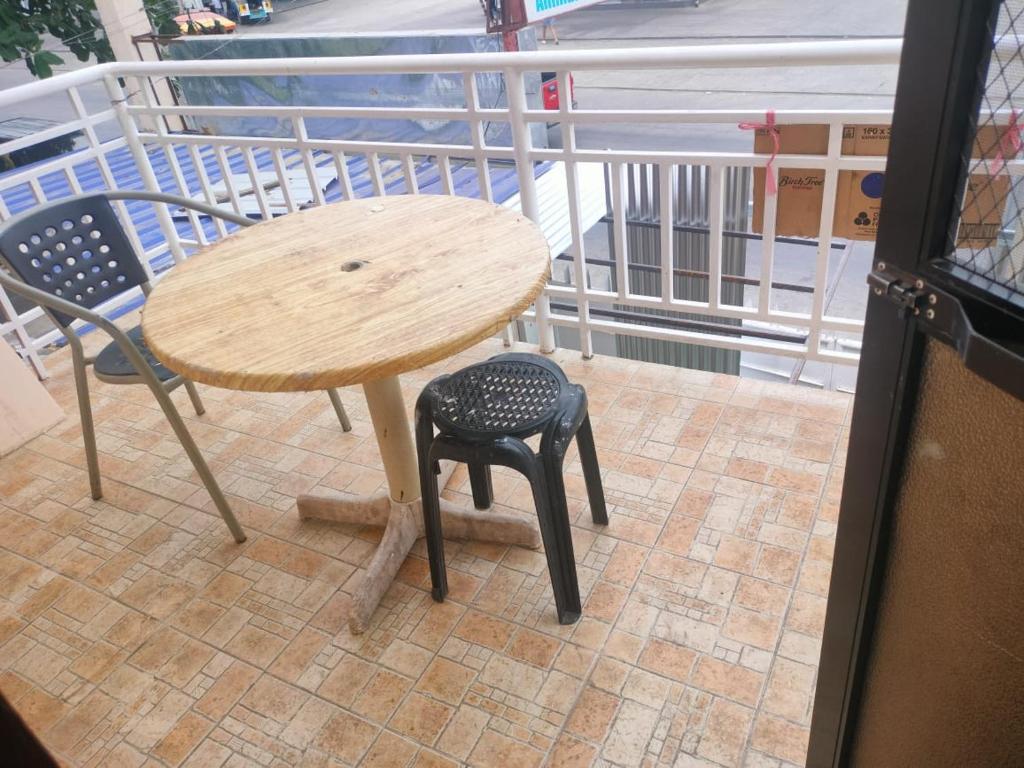 卡加延德奧羅的住宿－THE TAJ Inn，一张木桌和一张桌子及椅子旁边的凳子