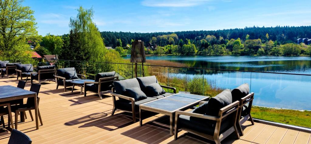 taras ze stołami i krzesłami oraz widokiem na jezioro w obiekcie Hotel GLAR Conference & SPA w Wisełce
