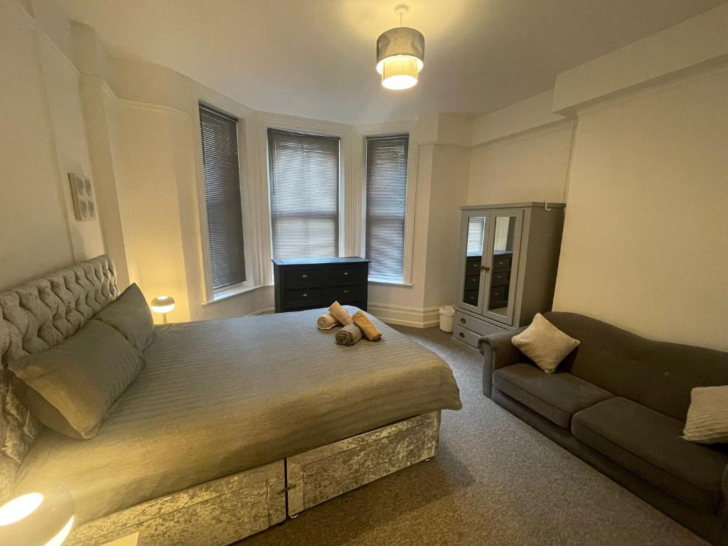 a bedroom with a large bed and a couch at Luxury,Location and Convenience in Bournemouth