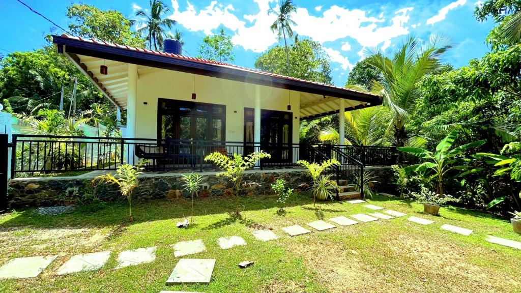 une maison avec un jardin en face dans l'établissement White Villa Goyambokka, à Tangalle