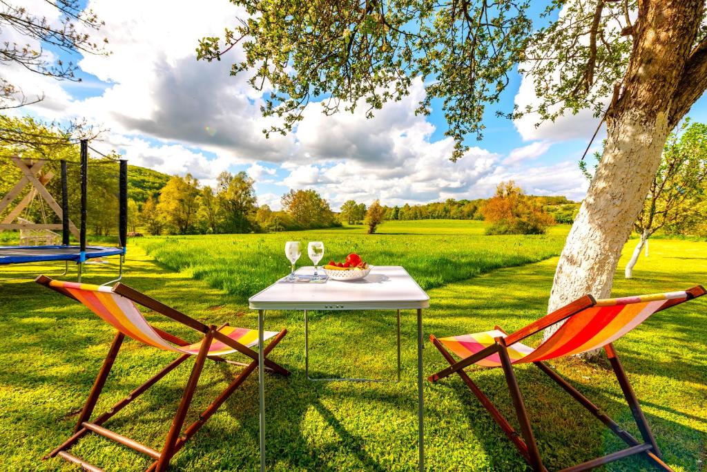 un tavolo con due sedie e un tavolo con bicchieri da vino di Guesthouse Diva Grabovčeva a Perušić