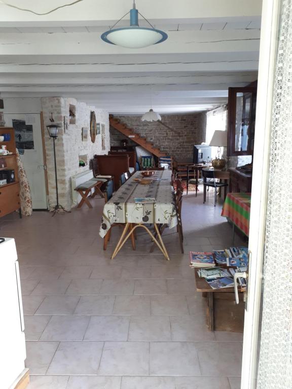 een grote woonkamer met een tafel en stoelen bij maison grange in Sainte-Marie-de-Ré