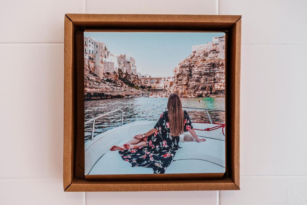 a picture of a woman sitting on a boat in the water at Acquaterra in Polignano a Mare