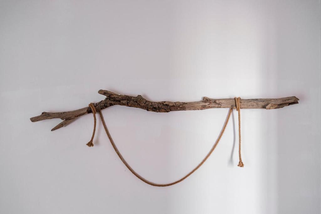 a piece of driftwood hanging on a white wall at Acquaterra in Polignano a Mare