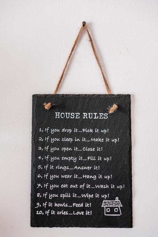 a sign that says house rules hanging on a wall at Acquaterra in Polignano a Mare