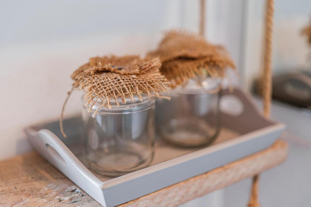 three glass jars sitting on a tray on a table at Acquaterra in Polignano a Mare