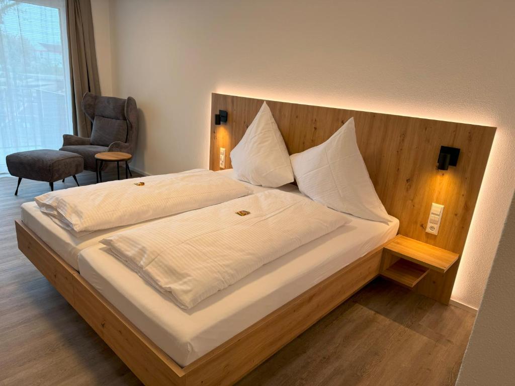Schlafzimmer mit einem großen Bett mit einem Kopfteil aus Holz in der Unterkunft MEIN MOTEL - Self Check-in 