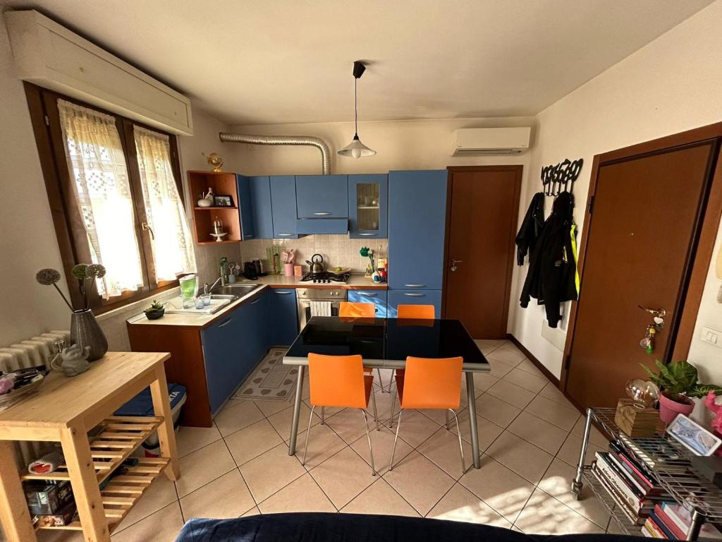 una cucina con armadi blu, tavolo e sedie di La casetta di Molly a Forlì