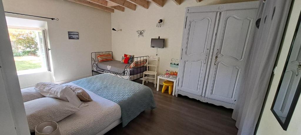 une chambre avec un lit, une chaise et une fenêtre dans l'établissement Chambre d'hôte La Voilerie du Cher, à Saint-Georges-sur-Cher