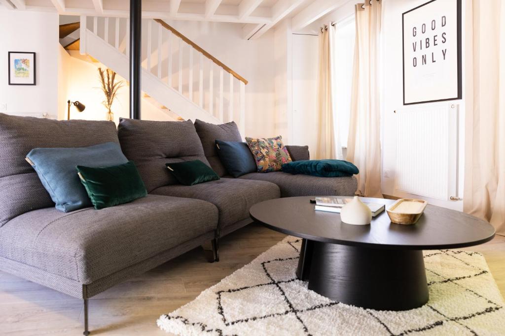 a living room with a couch and a table at Les Maisons de l'Abreuvoir Côté Village in Marly-le-Roi