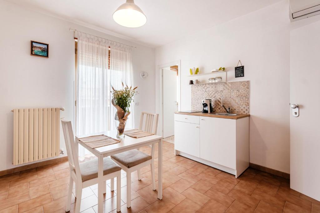 a white kitchen with a table and chairs and a counter at Acquaterra in Polignano a Mare