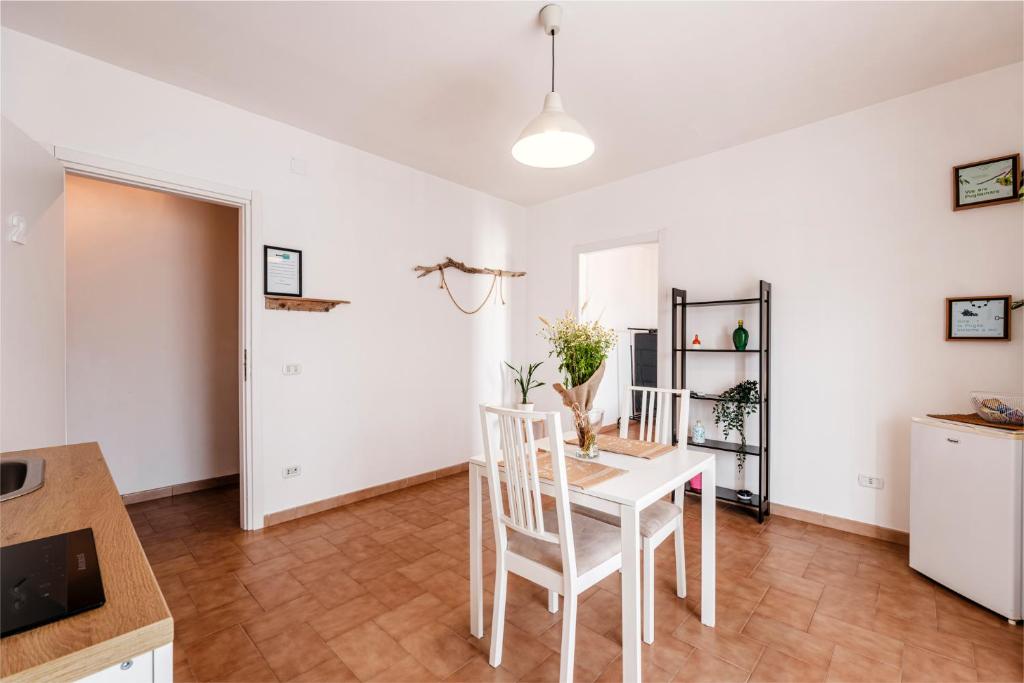 a kitchen and dining room with a white table and chairs at Acquaterra in Polignano a Mare