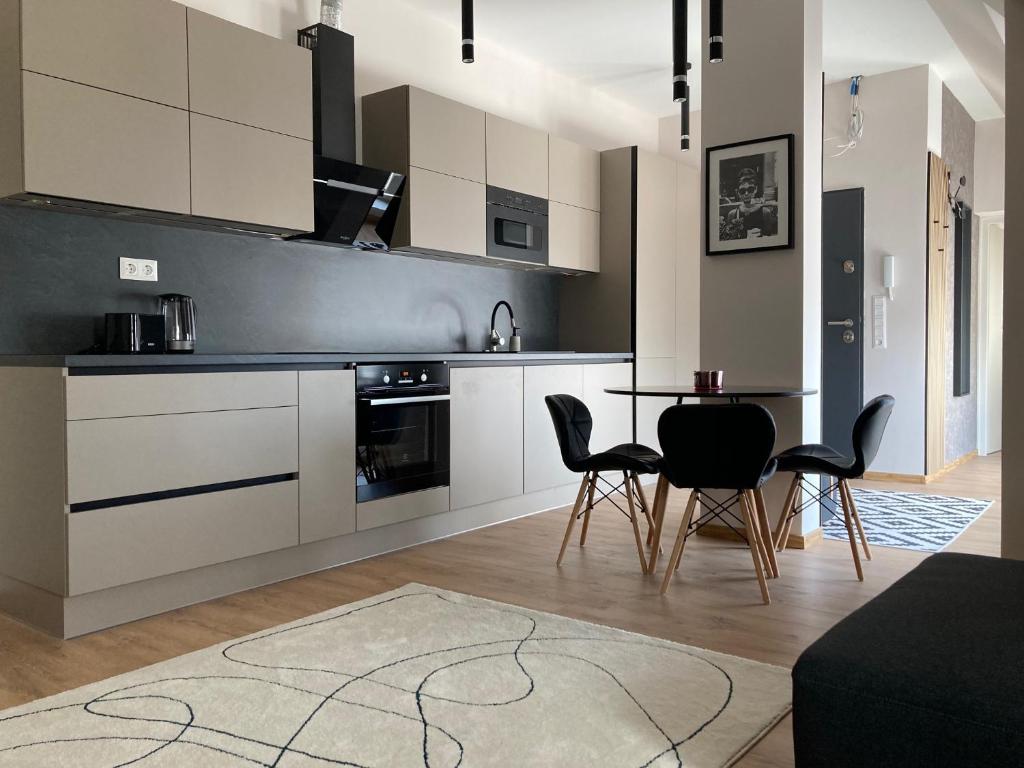 Hotel Buda Panorama Terrace Apartment, a kitchen with white cabinets and a table and chairs at Buda Panorama Terrace Apartment in Budapest