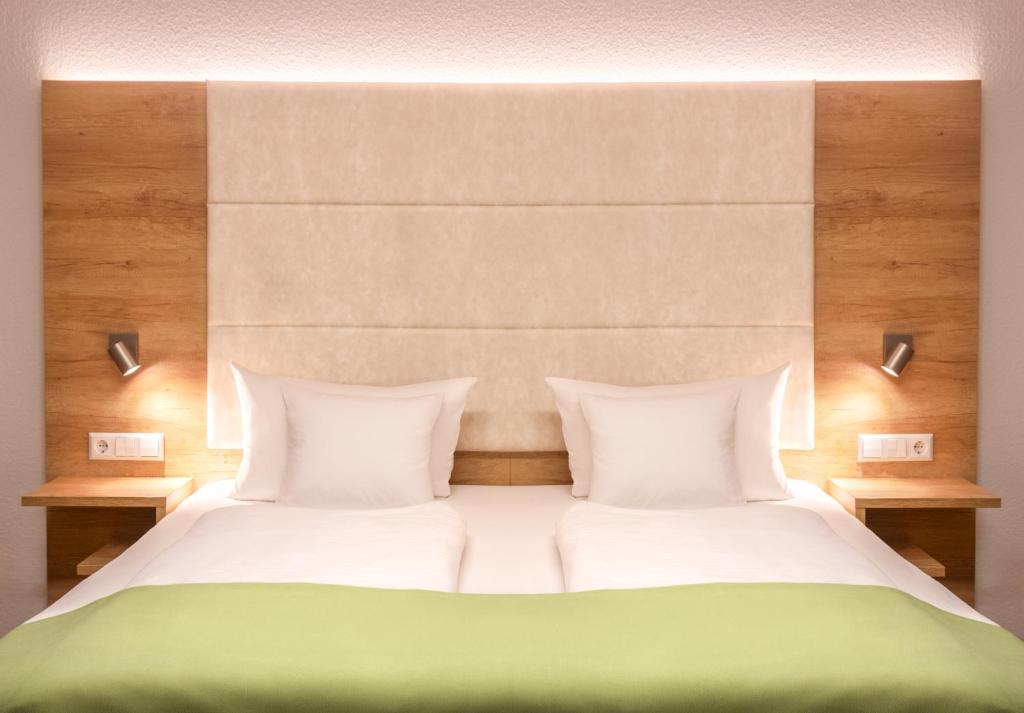 Postel nebo postele na pokoji v ubytování Hotel & Gästehaus Im Ziegelweg KLIMATISIERT Eintrittskarten für den Europa-Park erhalten Sie garantiert über uns