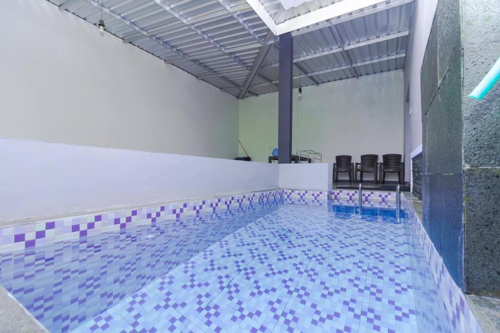 Una gran piscina con sillas en un edificio. en Villa Tera Private Pool and Karaoke, en Tlekung