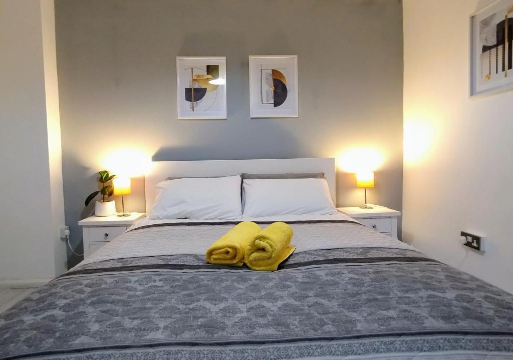 een slaapkamer met een bed met twee gele handdoeken erop bij 2 Beds House in City Center in Birmingham