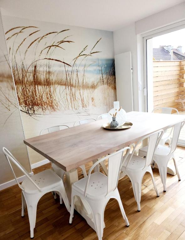 une salle à manger avec une table et des chaises en bois dans l'établissement Superbe duplex 50 mètres de la plage, à Le Portel