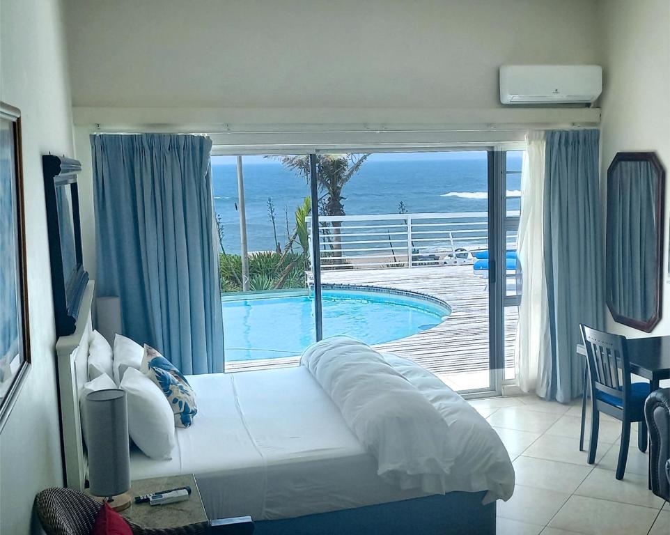 a bedroom with a bed with a view of a swimming pool at Bentley on the Beach in Durban