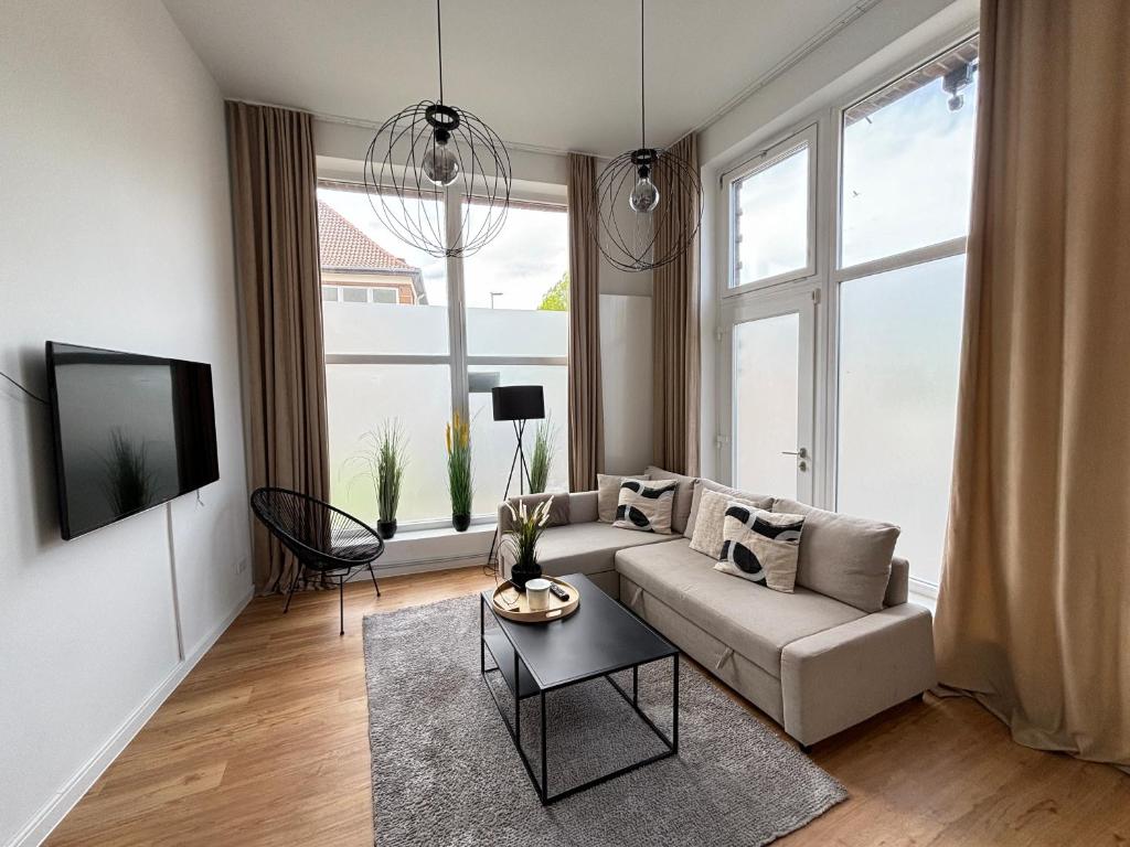 uma sala de estar com um sofá e uma televisão em 60qm - 2 rooms - free parking - city - MalliBase Apartments em Hanôver