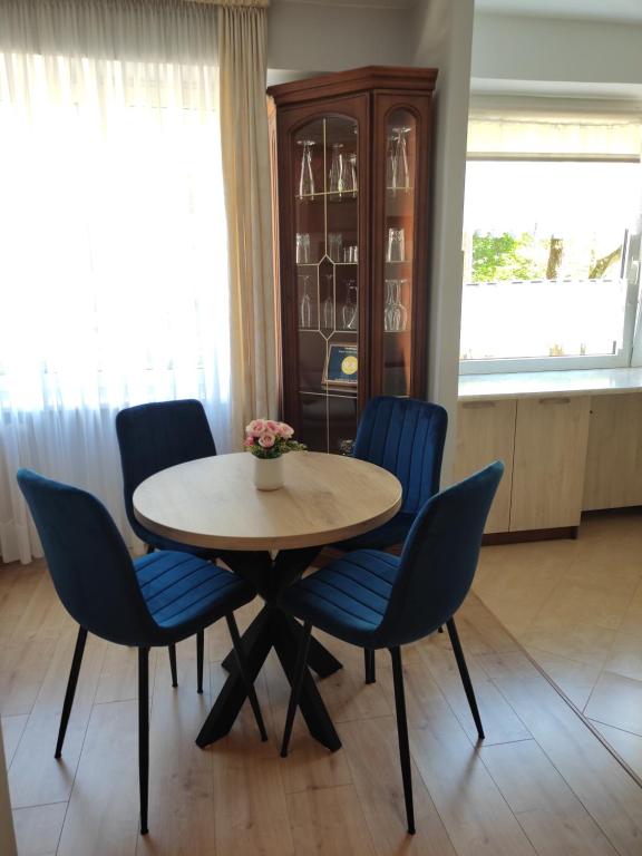 a dining room with a table and blue chairs at Apartament Familijny in Olsztyn