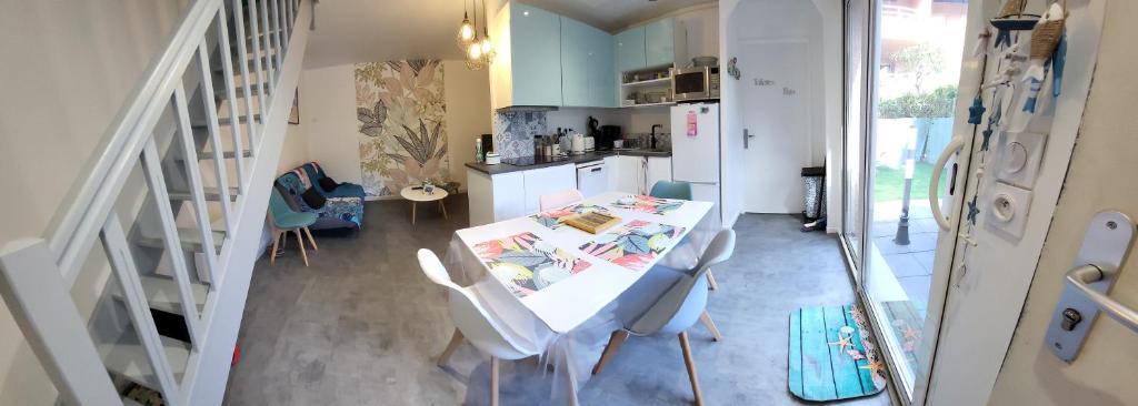 eine Küche mit einem Tisch und Stühlen im Zimmer in der Unterkunft Pierres de Jade Maison de vacances en residence avec piscine in Saint-Cyprien