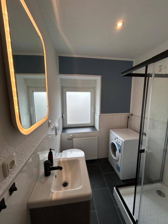 a bathroom with a sink and a washing machine at Wohnung über Restaurant in Alsdorf