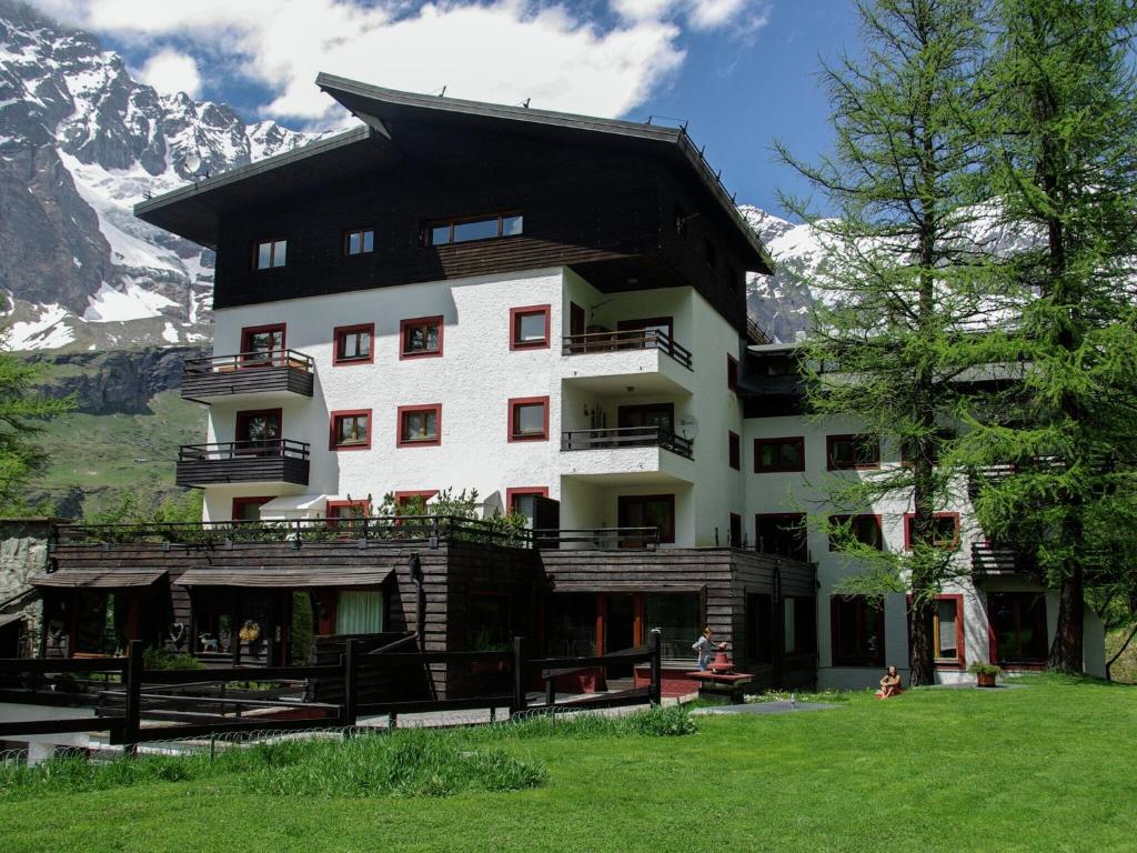 a building in the mountains with mountains in the background at Contemporary Apartment in Breuil Cervinia near Ski Area in Breuil-Cervinia