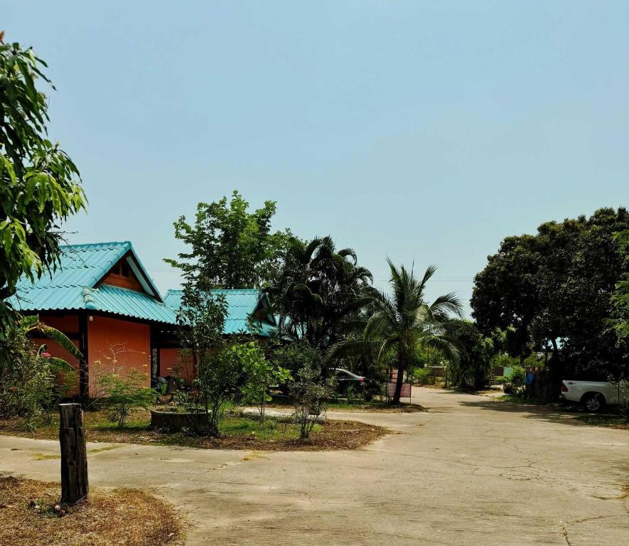 ein Gebäude mit blauem Dach neben einer Straße in der Unterkunft OYO 75489 Leelawadee NonPho Resort (Amnatcharoen) in Amnat Charoen